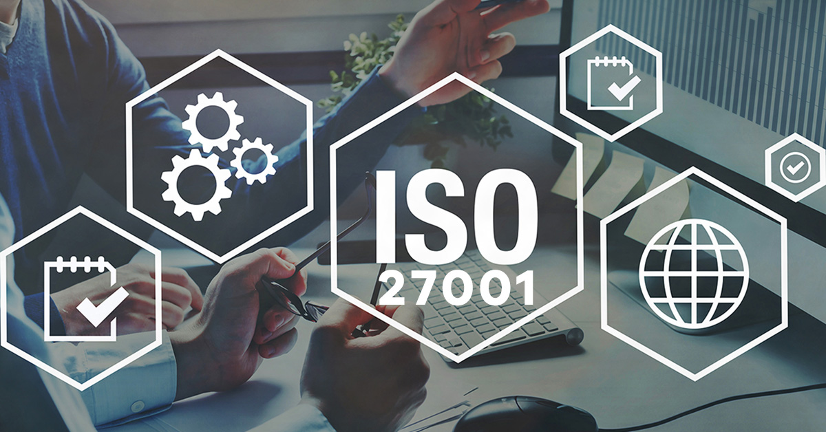 Two professionals discuss ISO 27001 certification, with digital icons representing security standards overlaying the office setting.