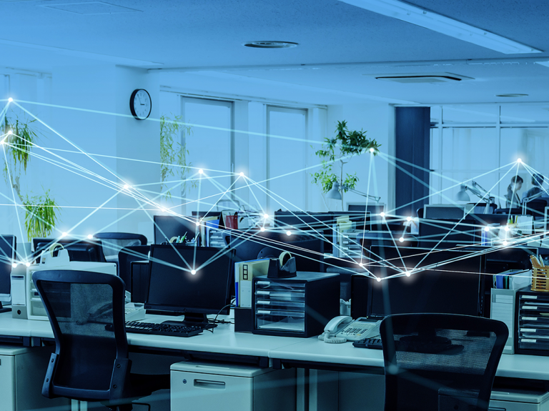 Modern office at night with computer screens, desks, and abstract illuminated business internet connections overlaying the scene.