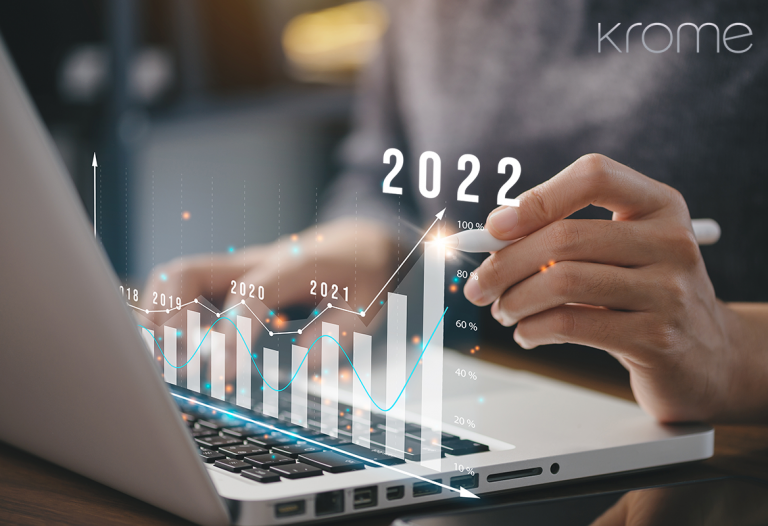 Person analyzing a financial graph for the years 2019-2022 on a Krome Technologies laptop screen, with digital enhancement showing growth trend.