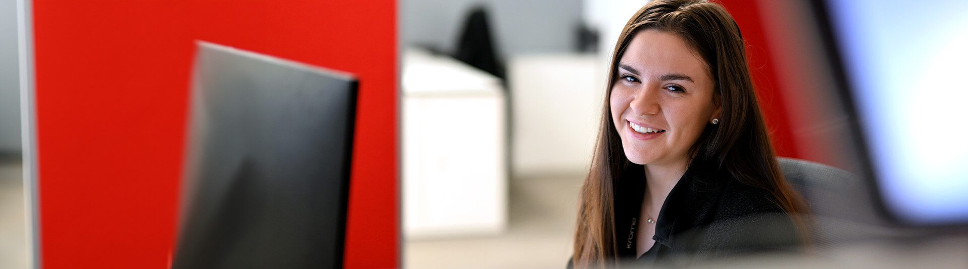 smiling co-worker with red backdrop