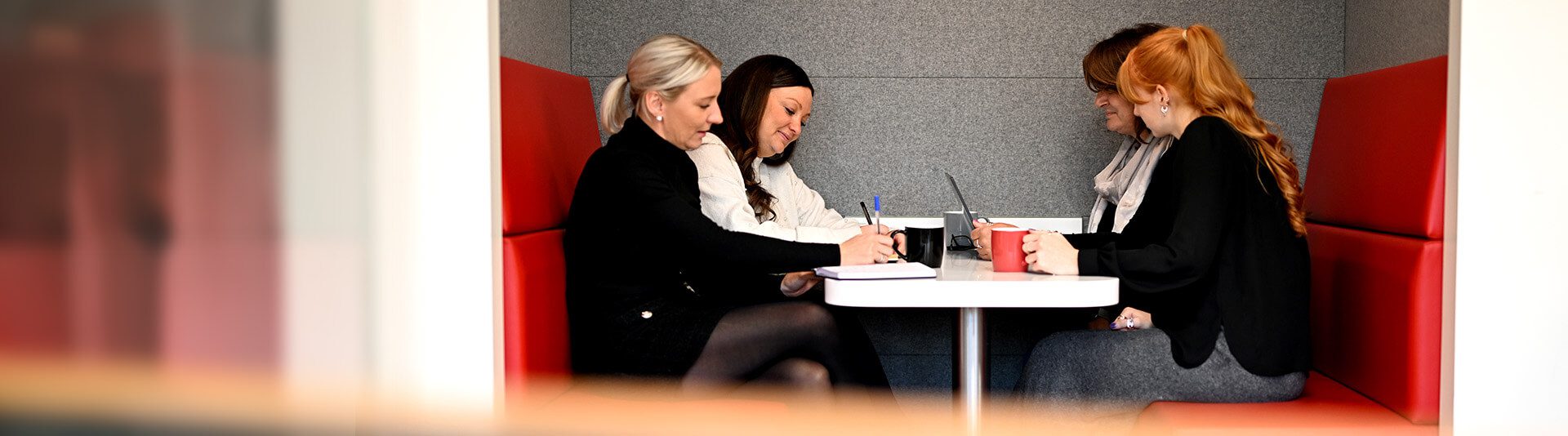 Meeting around table in red booth