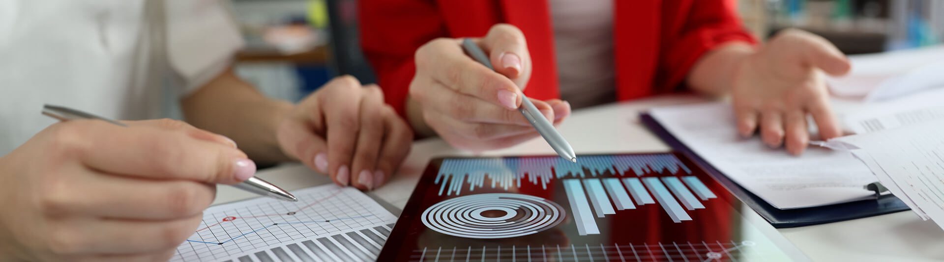 People working at desk with tablet and spreadsheet