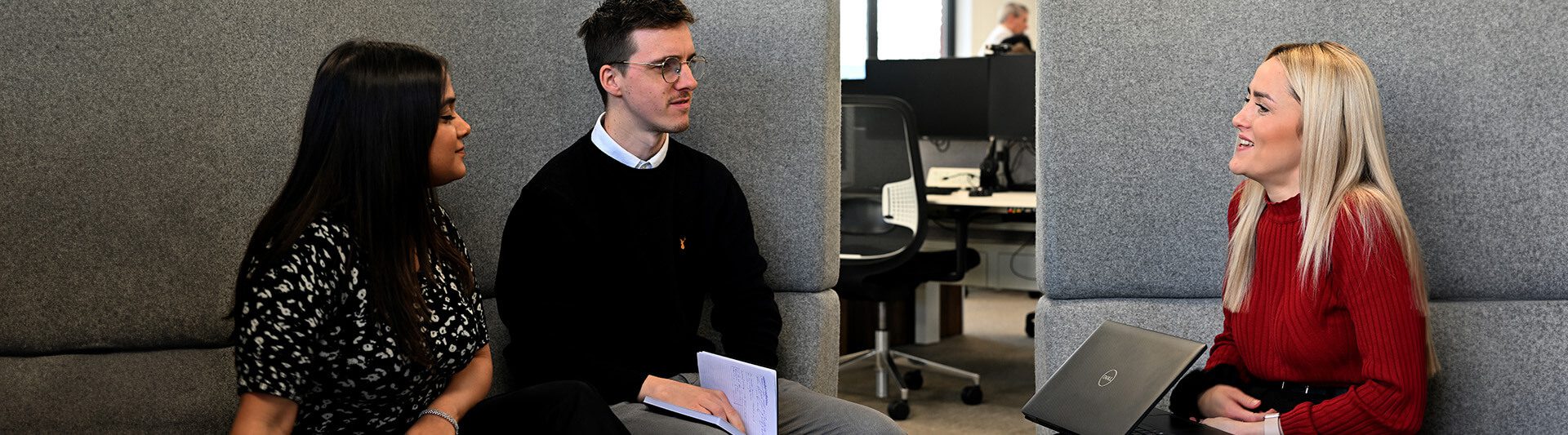 Seated co-workers having a meeting in a booth about technical consultancy services